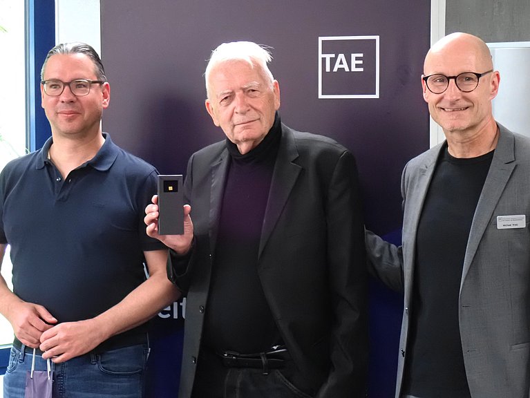 Von links nach rechts: Dr. Michael Heide, Geschäftsfeldleiter für Medizintechnik, Gesundheitswesen, HCM und Qualitätsmanagement, Dr. med. Wolfgang Scherrenbacher mit der Ehrennadel sowie Michael Walz, Vorstand der TAE.